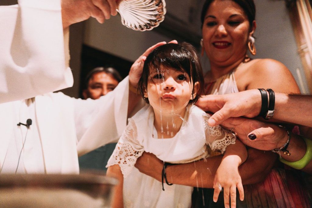 La cara del bebé al recibir el agua bautismal, fotografiado en Gáldar